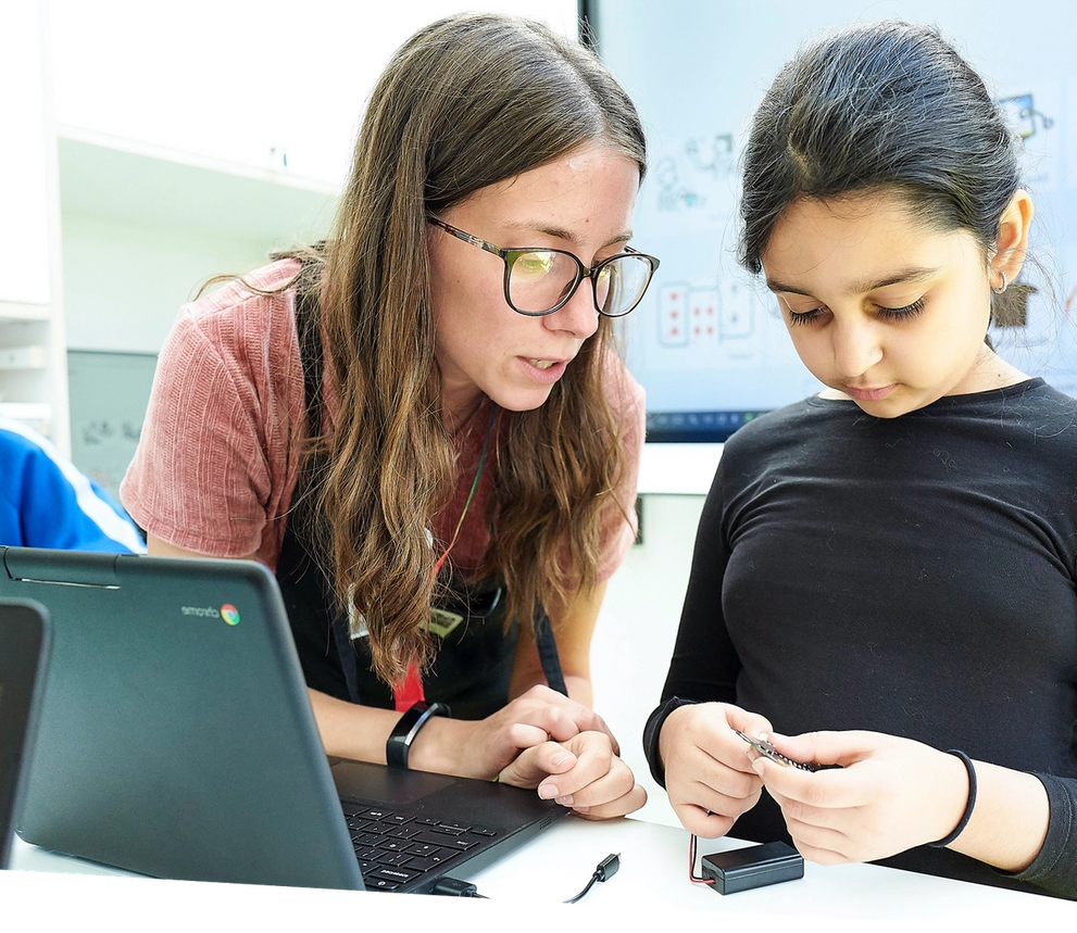 Mestre ajudant l'alumne a explorar la micro:bit 