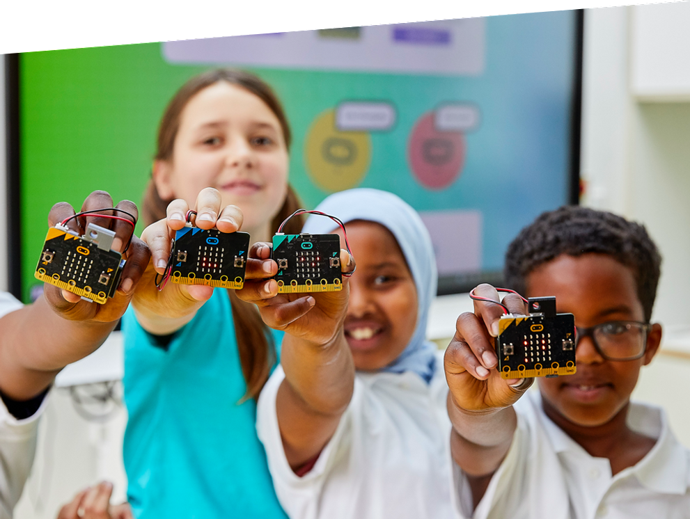 nens a la classe somrient i sostenint micro:bits