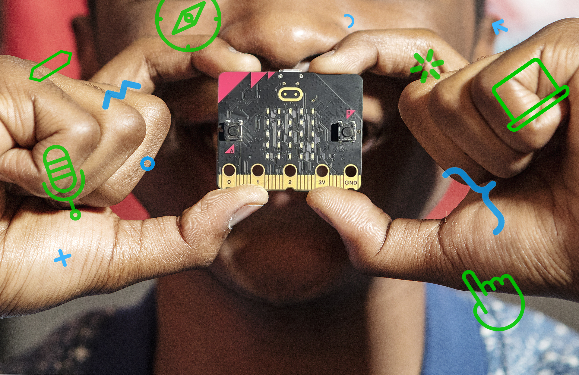 foto en primer pla d'un infant sostenint una placa micro:bit entre els dits sobre la seva cara